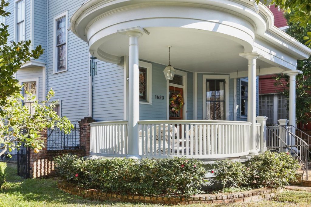 Restored Victorian New Orleans home with a curved wraparound porch